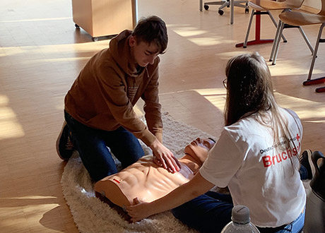 Erste-Hilfe-Kurs - Schüler üben eine Herzdruckmassage an einer Puppe
