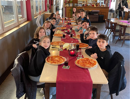 Ausflug Pizzeria 24_Schüler mit Pizzen im Restaurant